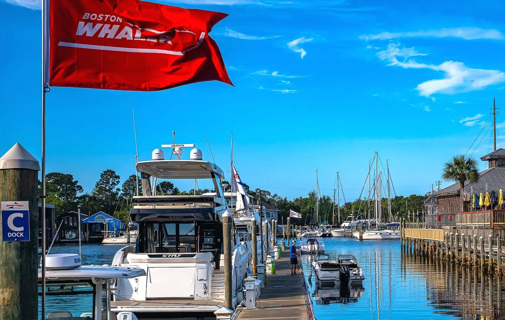 A colorful marina scene featuring boats docked along calm waterfront water in the Pensacola and Gulf Coast area. This image captures the relaxed coastal lifestyle, reflections, and working-waterfront atmosphere that define Northwest Florida. Ideal fo
