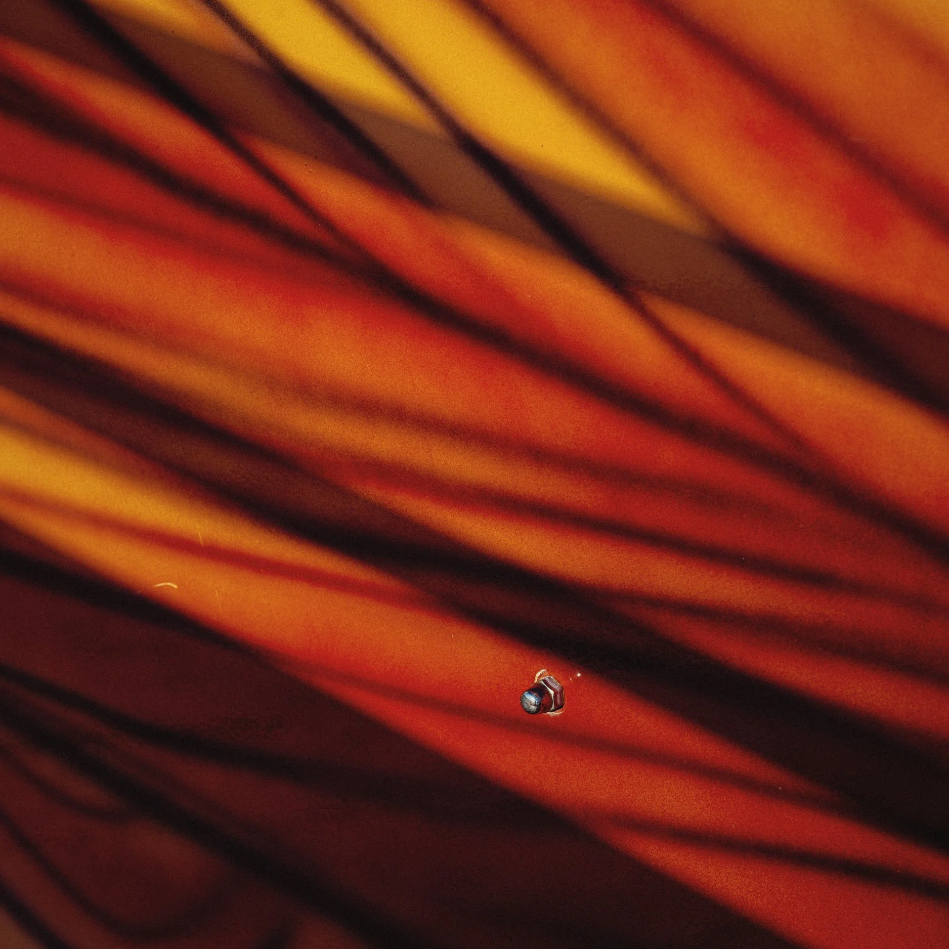 Close-up view of a striped surface with an eye dropper positioned near the bottom center.