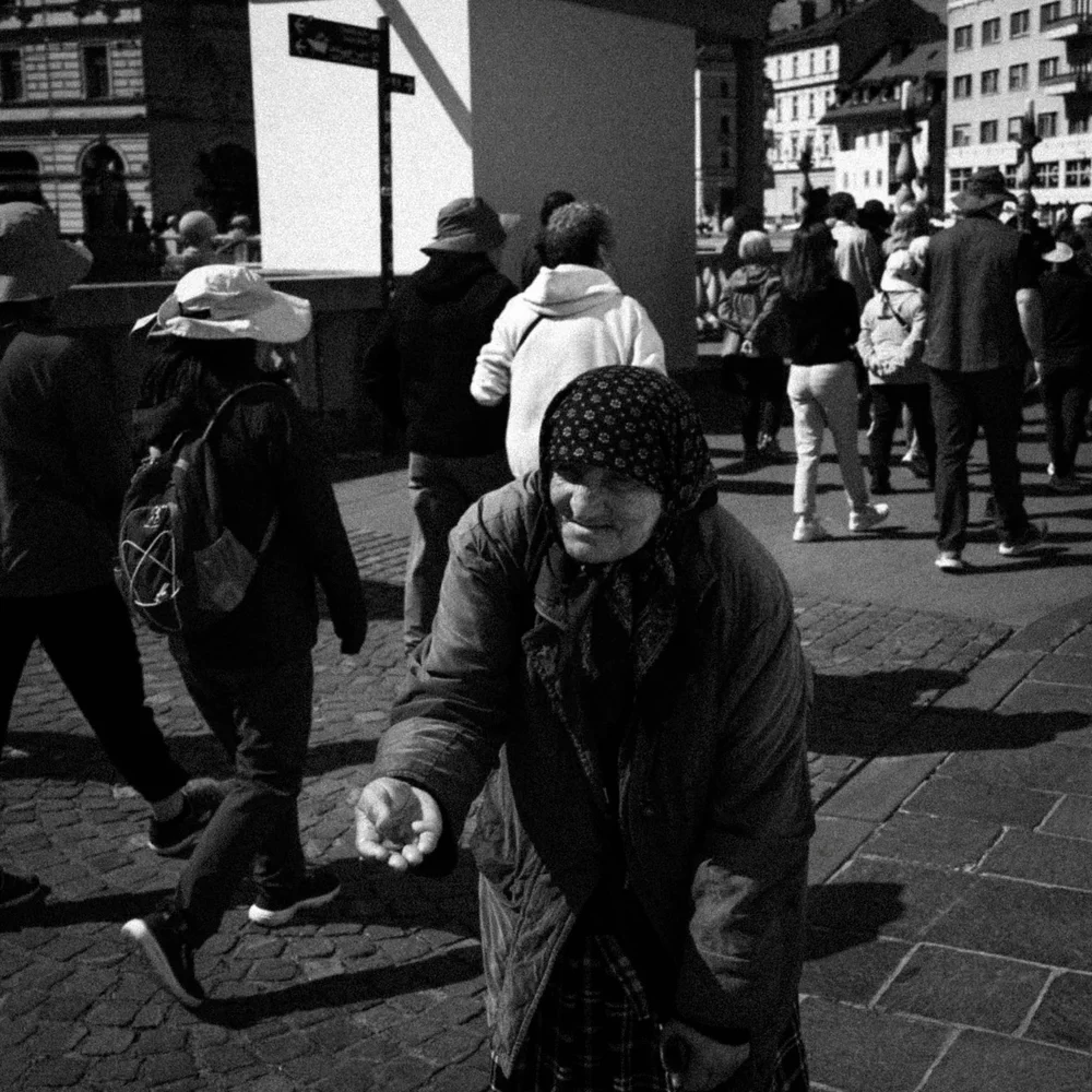 A woman reaching out in a busy city street, photographed in black and white