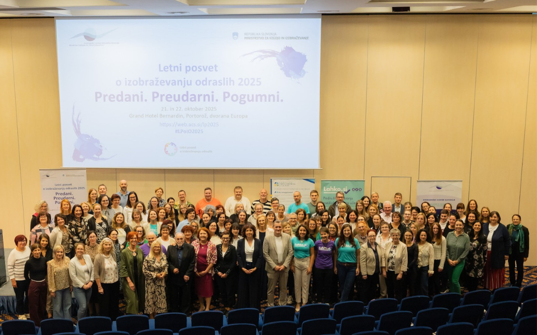 Conference participants gathered for a group photograph beneath the projected 2025 event title.