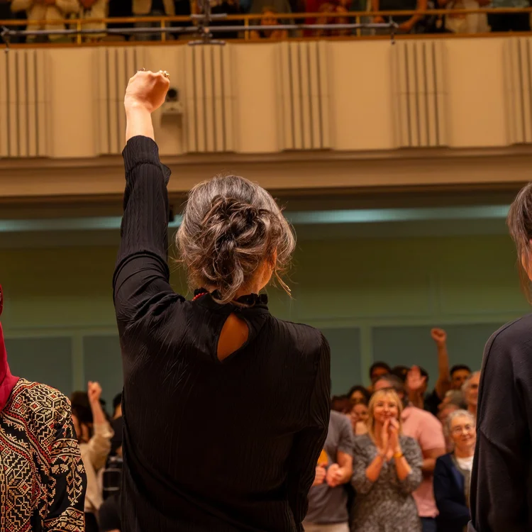 A person raises a fist in a city crowd