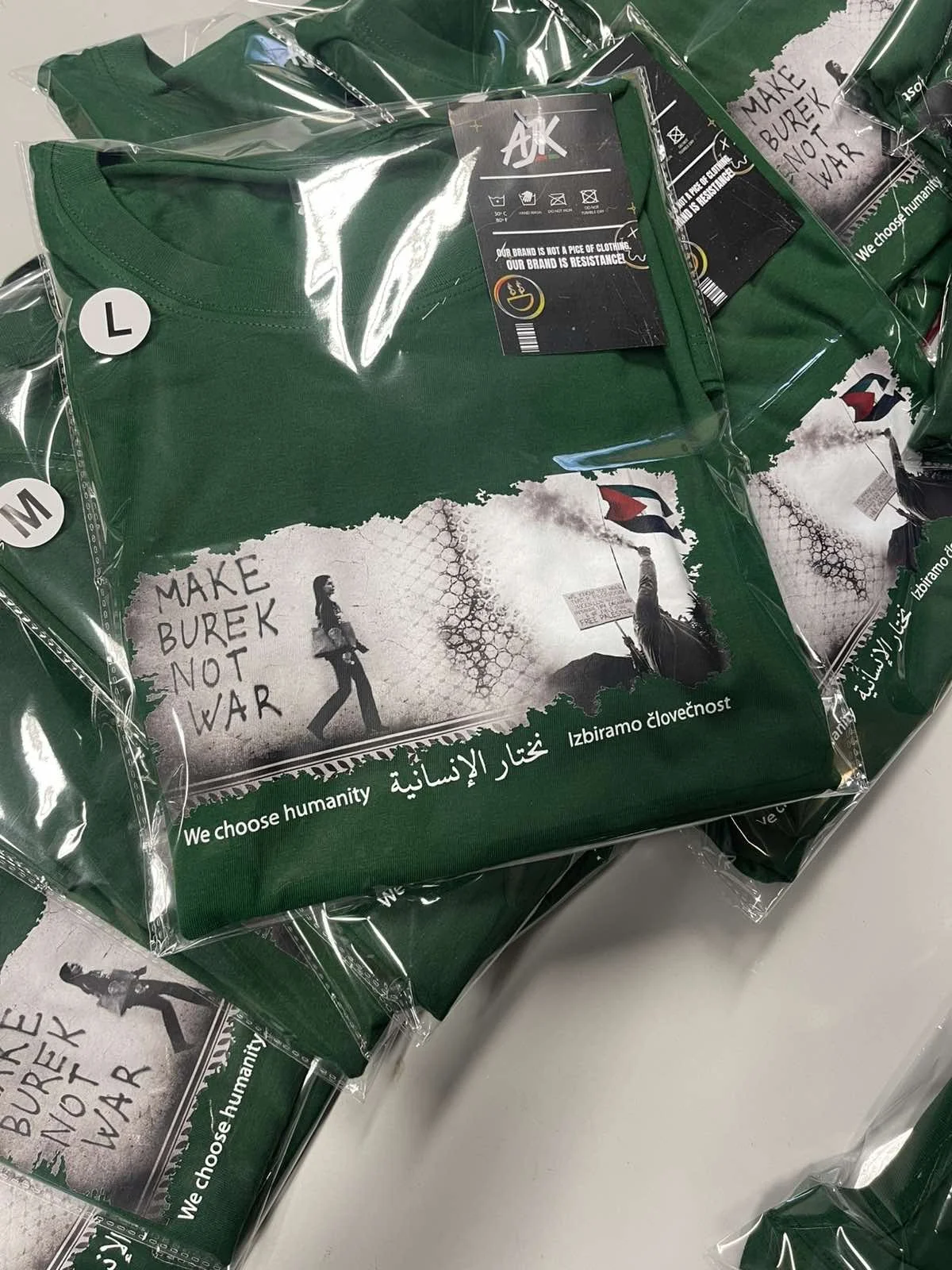 Green Make Burek Not War T-shirts in their packaging, with a photographic print and the words We choose humanity.