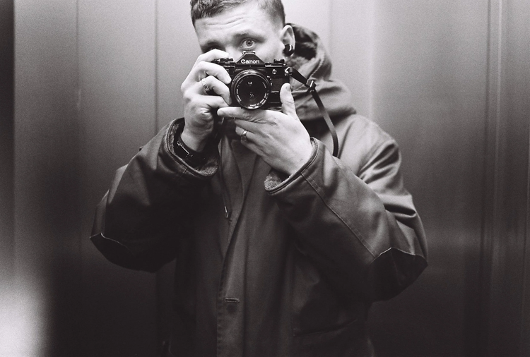 Črt Piksi photographing his reflection in an elevator mirror