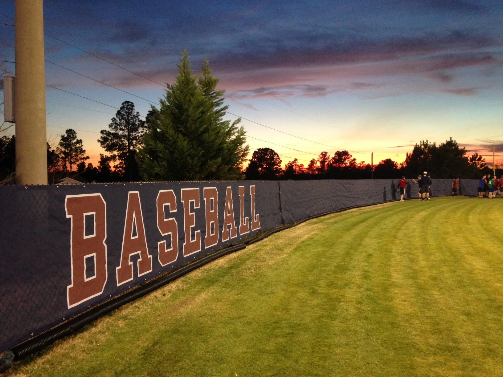 Baseball field wind screens installed by EFI USA for a high school baseball stadium