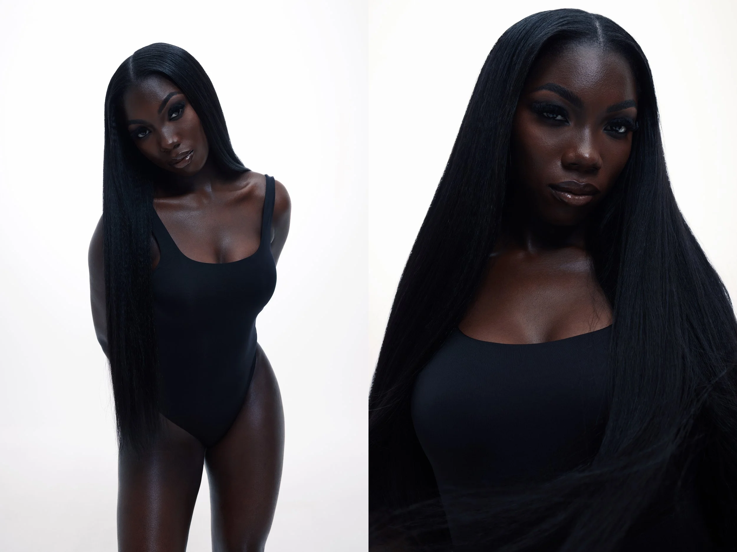 A woman with long black hair wearing a black one-piece outfit, posing against a plain white background.