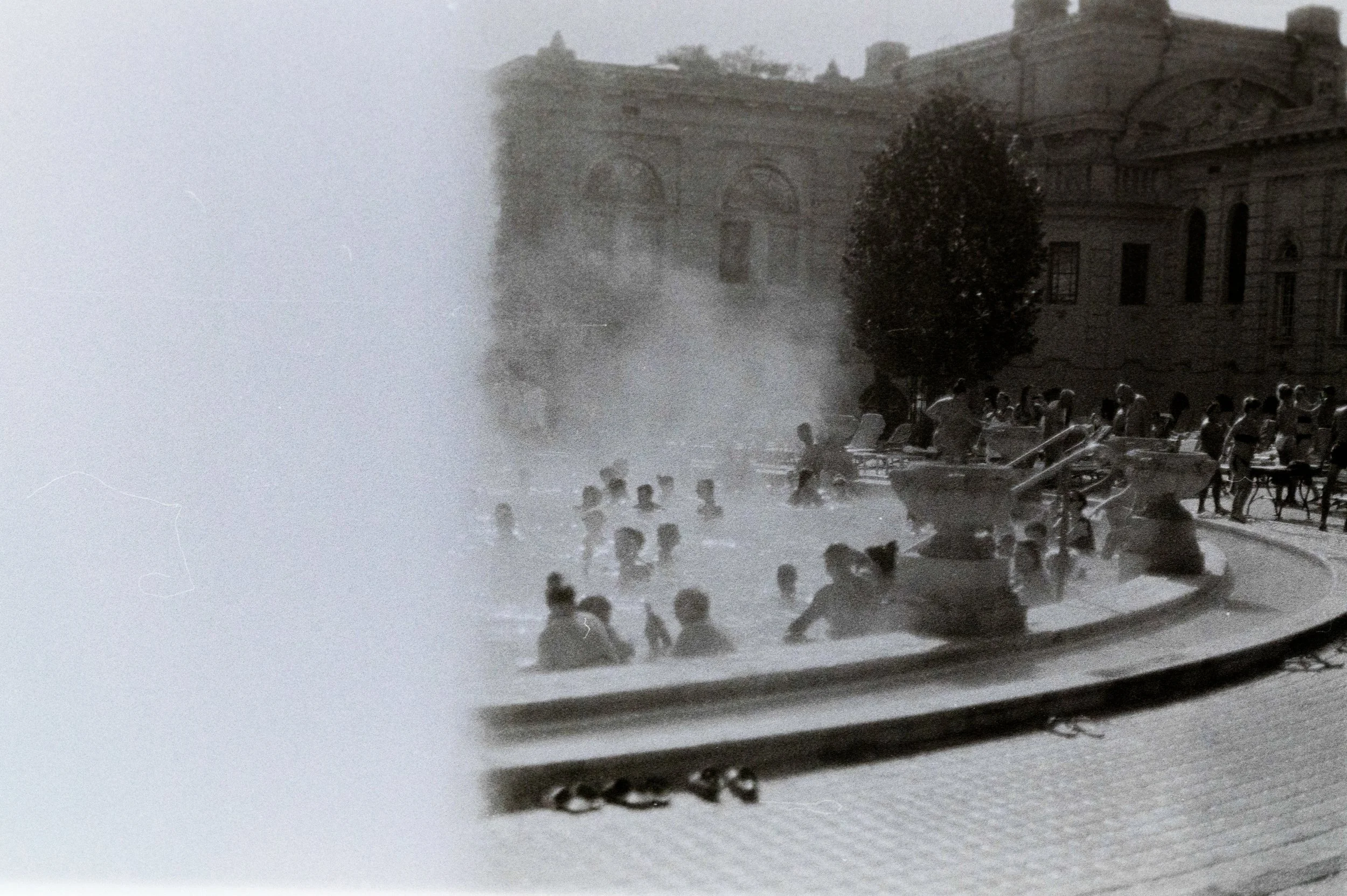 Persone che si bagnano in una fontana in un'area urbana.
