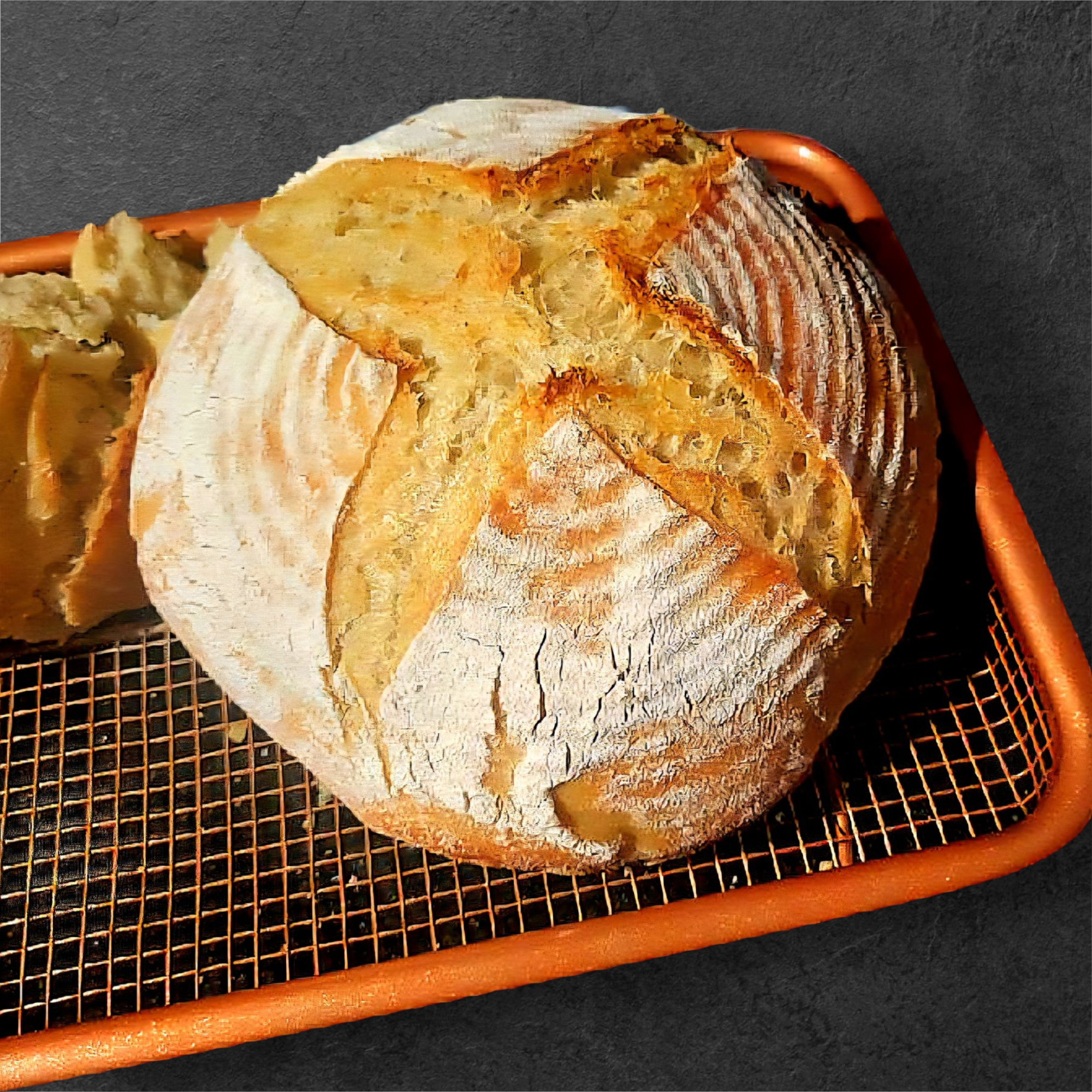 A loaf of rustic bread with a crispy, cracked crust on a wire cooling rack.