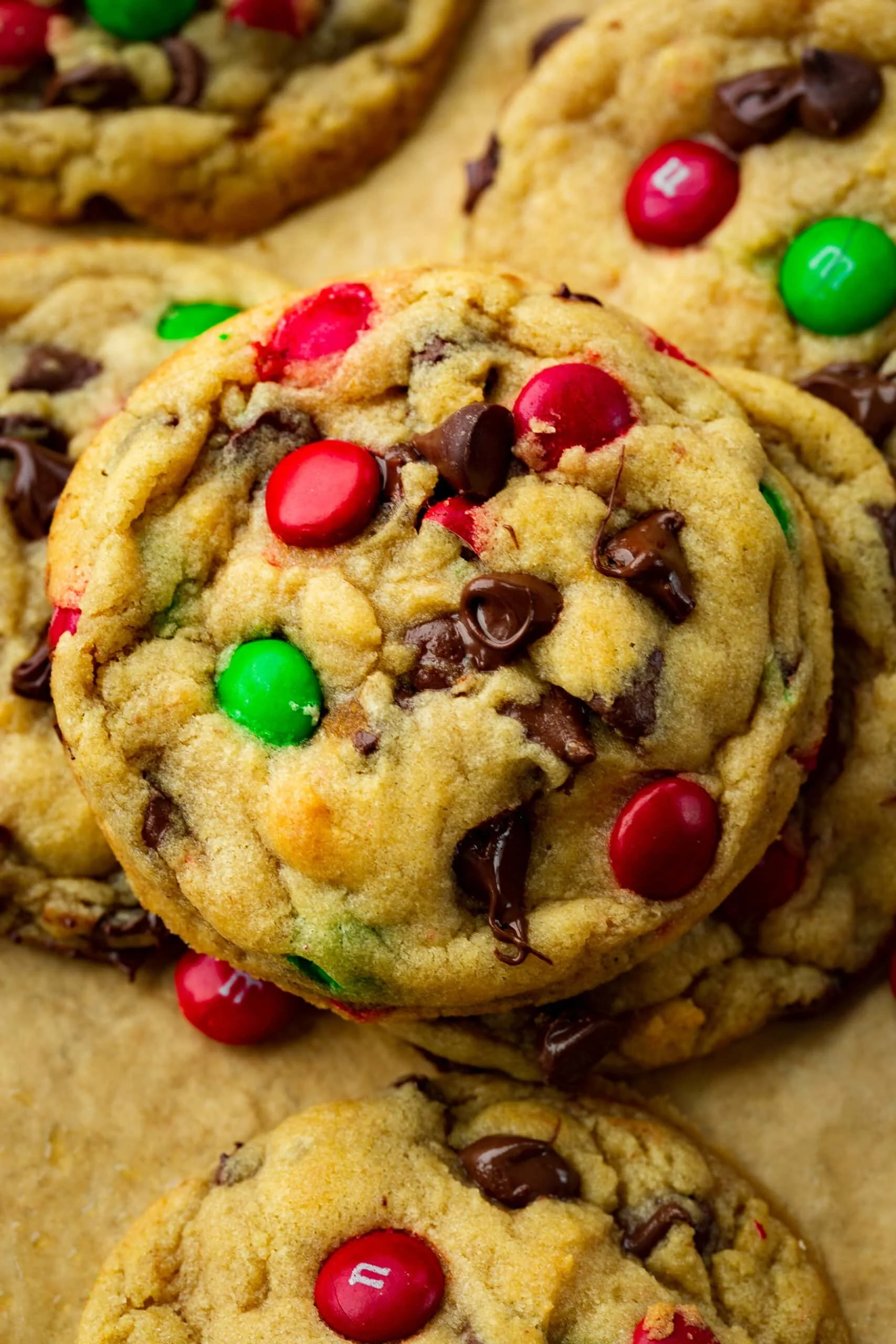 Close-up of chocolate chip cookies with red, green, and brown M&M candies.