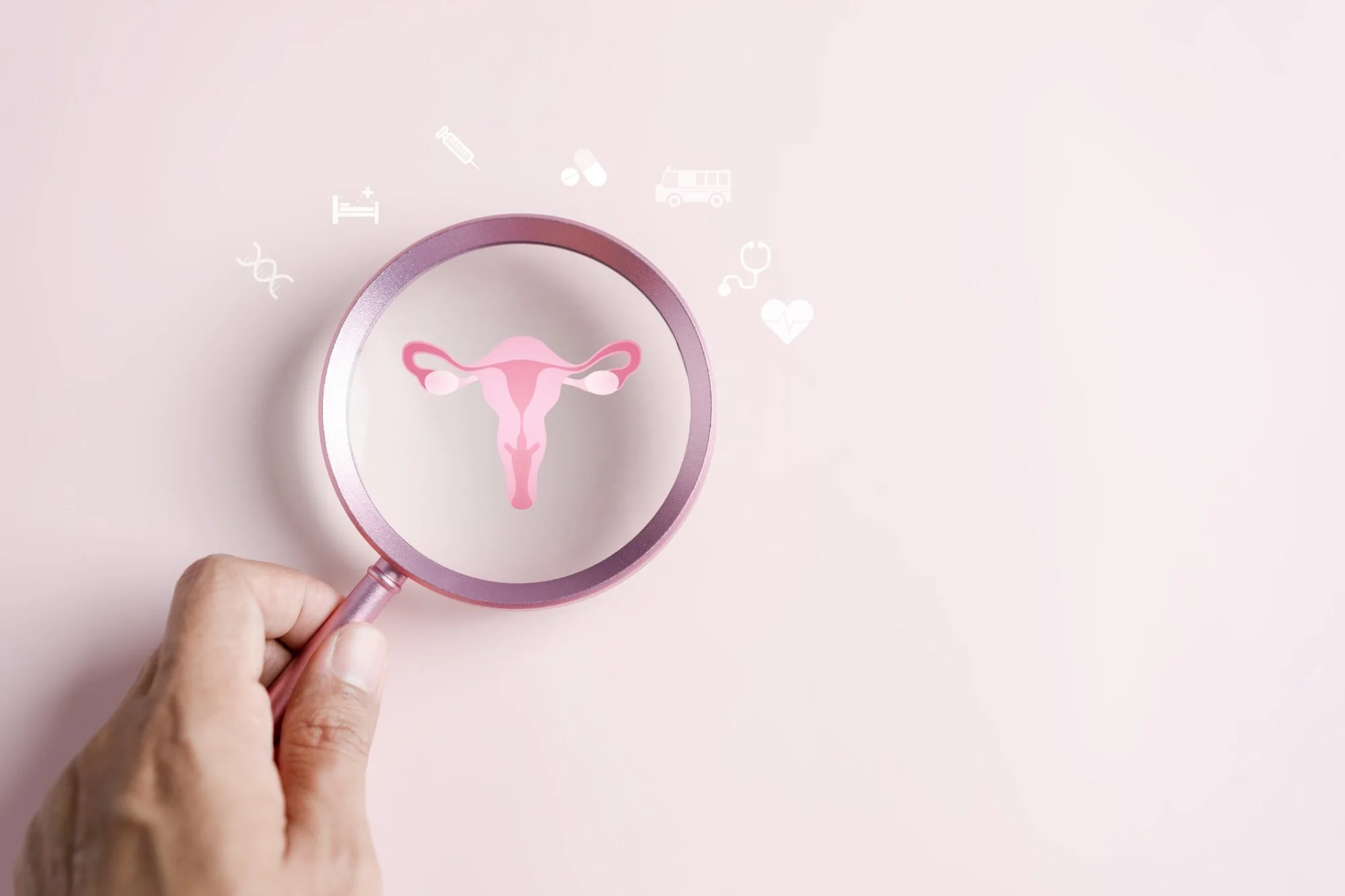 A hand holding a pink magnifying glass over a female reproductive system diagram, with medical icons floating around.