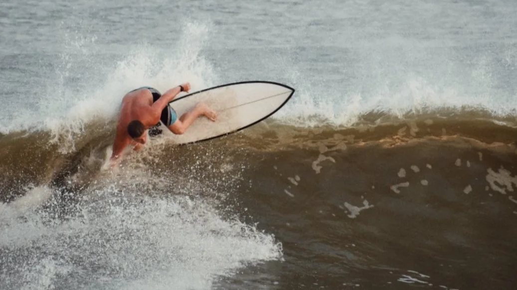A person surfing on a wave in the ocean.