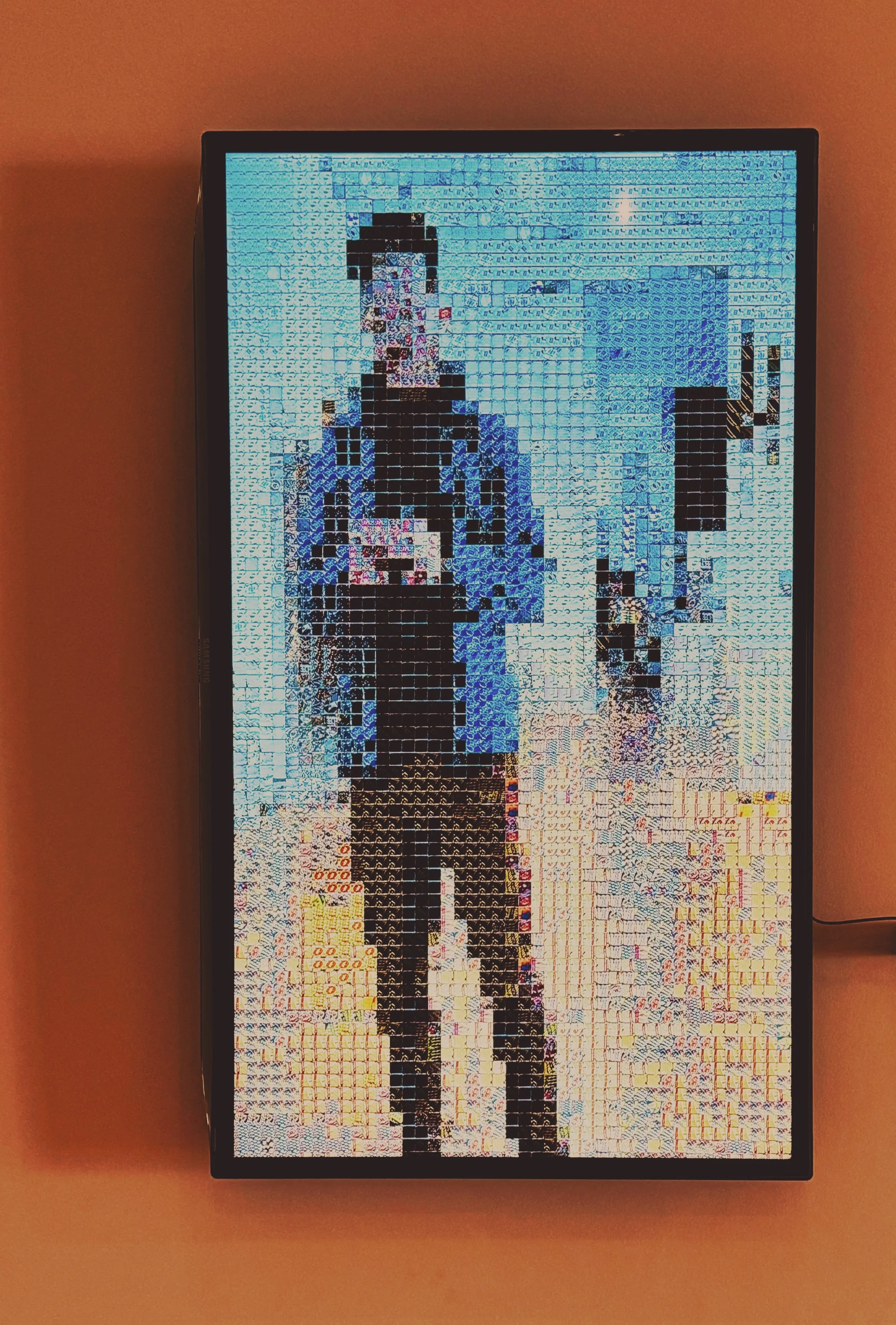 Digital mosaic of a person wearing a dark jacket and pants, standing outdoors, with a blue sky in the background, created from small, colorful tiles.