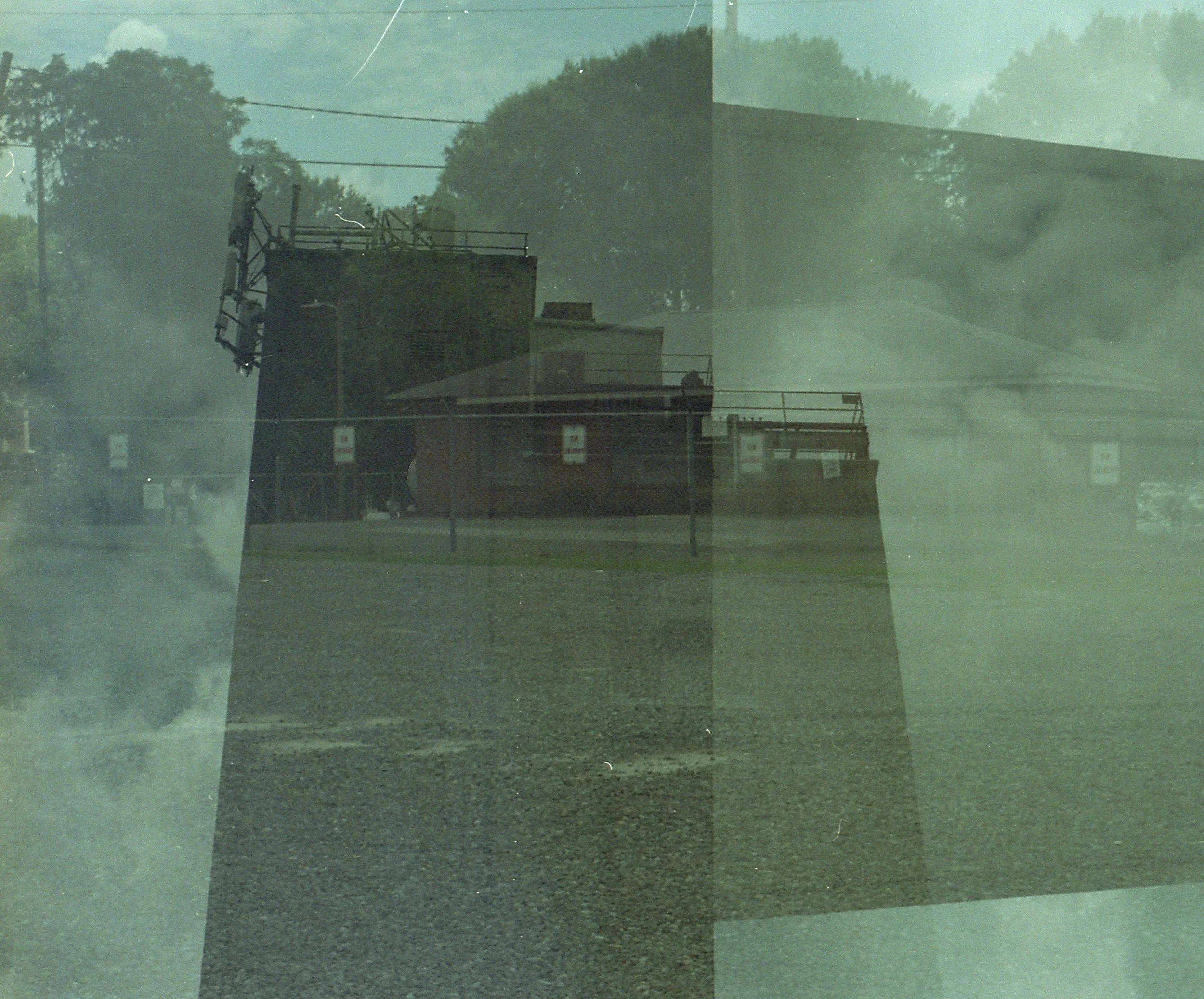 Double exposure photograph of a street scene with a building and trees, combined with a close-up of a person's face.