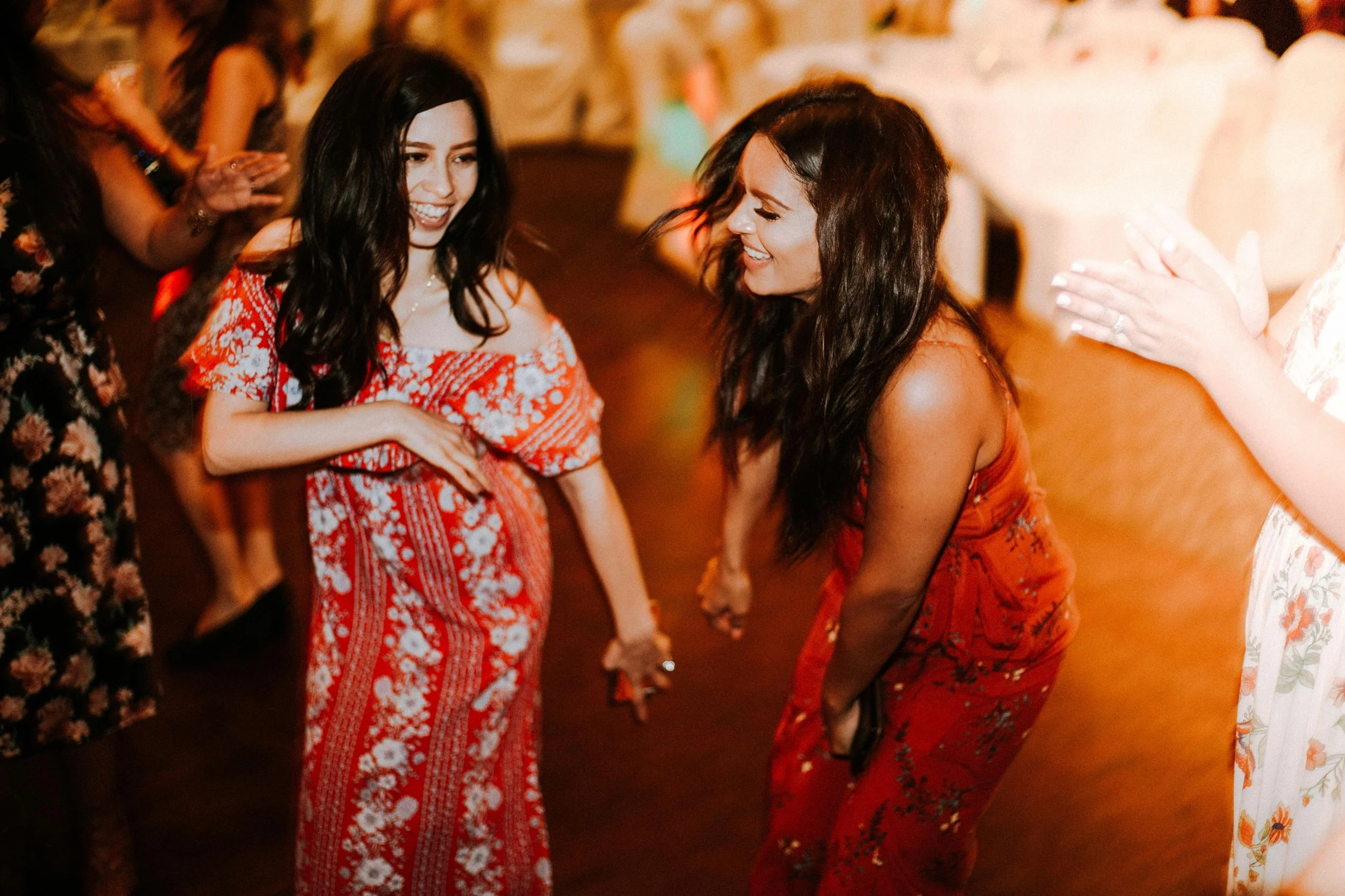 Two women dancing and laughing together at a dance party.