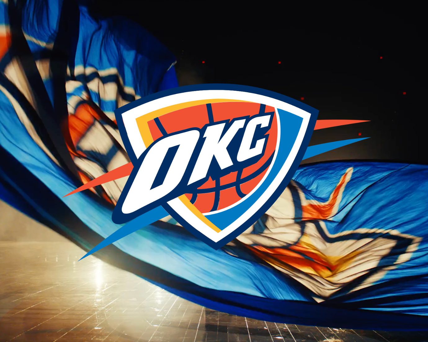 Image of a parachute with the Oklahoma City Thunder logo over it in a basketball arena.