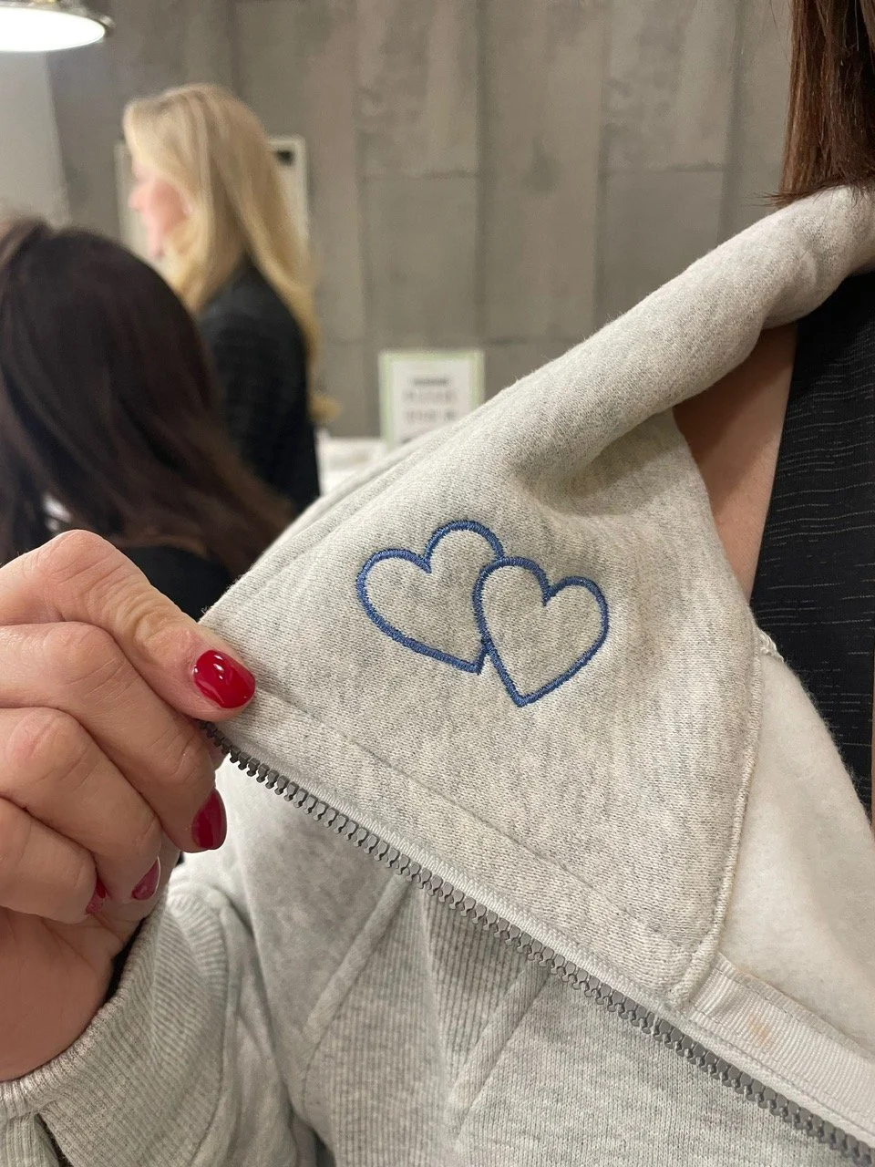 The image shows a grey Lululemon Scuba with two periwinkle colored embroidered hearts on the collar.