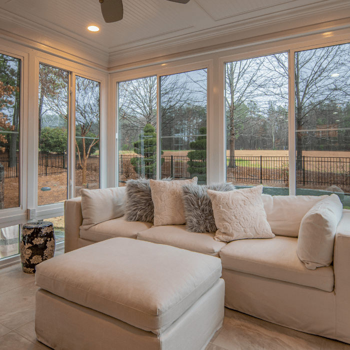 Tan sofa in front of surrounding windows