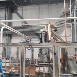 Industrial machinery with robotic arms and metal structures in a factory setting.