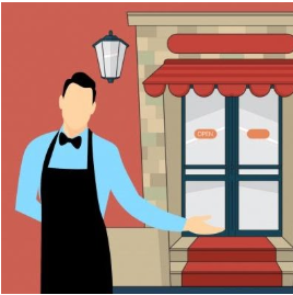 A waiter wearing a blue shirt and black apron standing outside a cafe or restaurant with a glass door, a red awning, and a streetlamp.