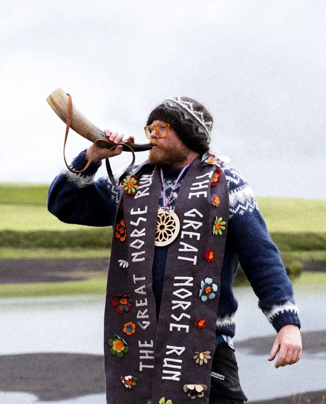 Danny Bent blowing a traditional horn during an outdoor Norse ceremony in Iceland