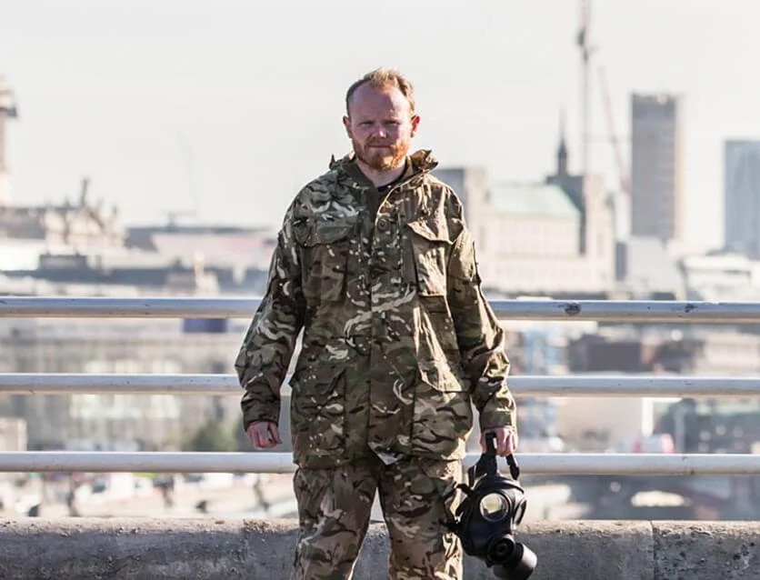 Danny Bent wearing camouflage military uniform and holding a helmet