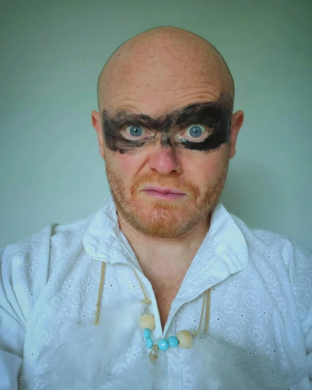 Danny Bent wearing black face paint across his eyes in a close portrait