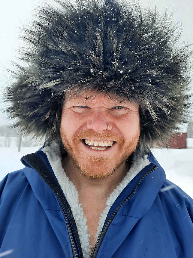Danny Bent smiling outdoors in cold weather during an outdoor expedition