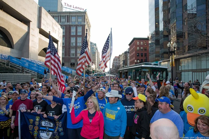 Large crowd gathered in Boston during a marathon event with American flags