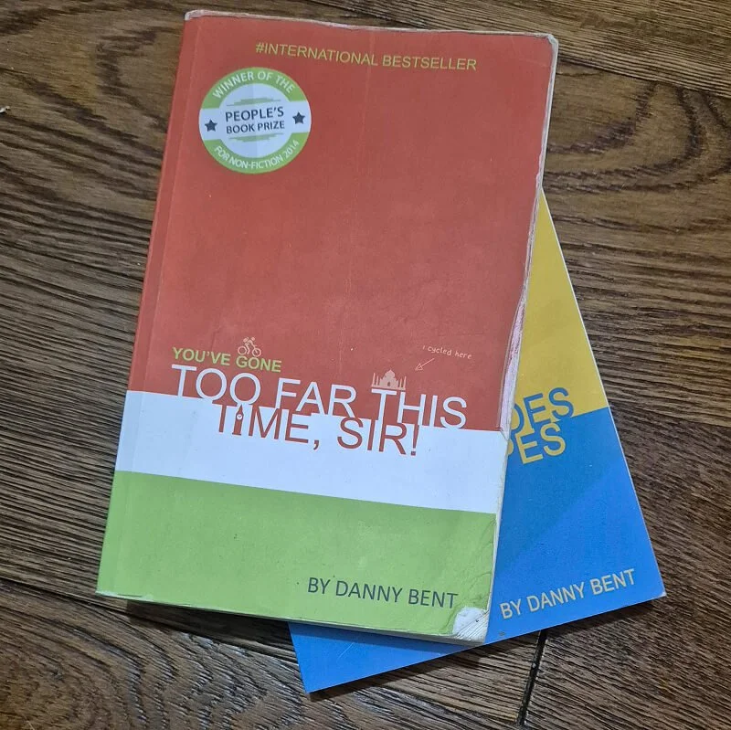 Two books by Danny Bent including “You’ve Gone Too Far This Time, Sir!” on a wooden surface