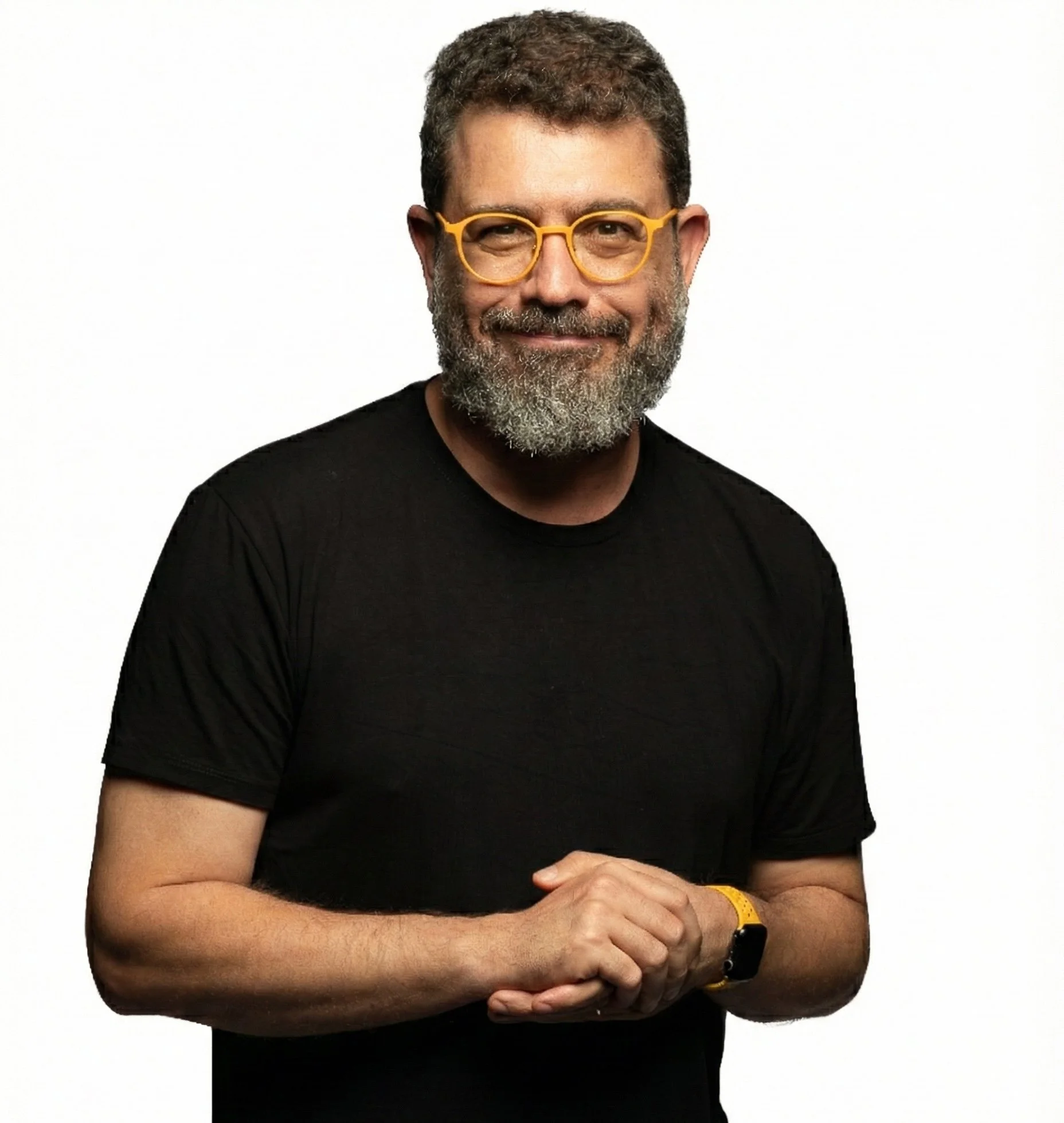 Fotografia de Pedro Doria, um homem com barba grisalha, usando óculos amarelos e uma camiseta preta, sorrindo, contra fundo branco.