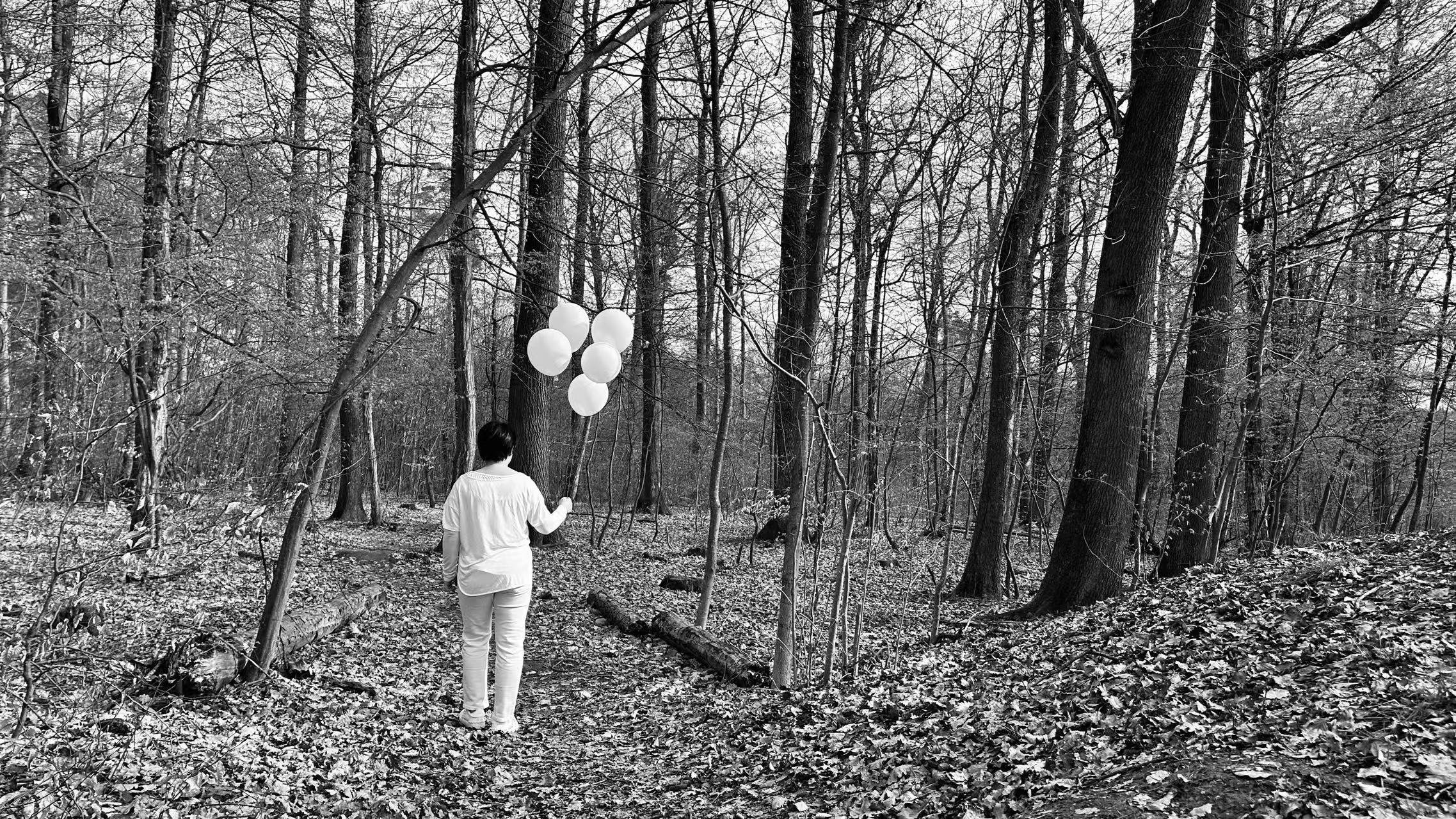 Motherhood is walking through a forest with balloons in hand