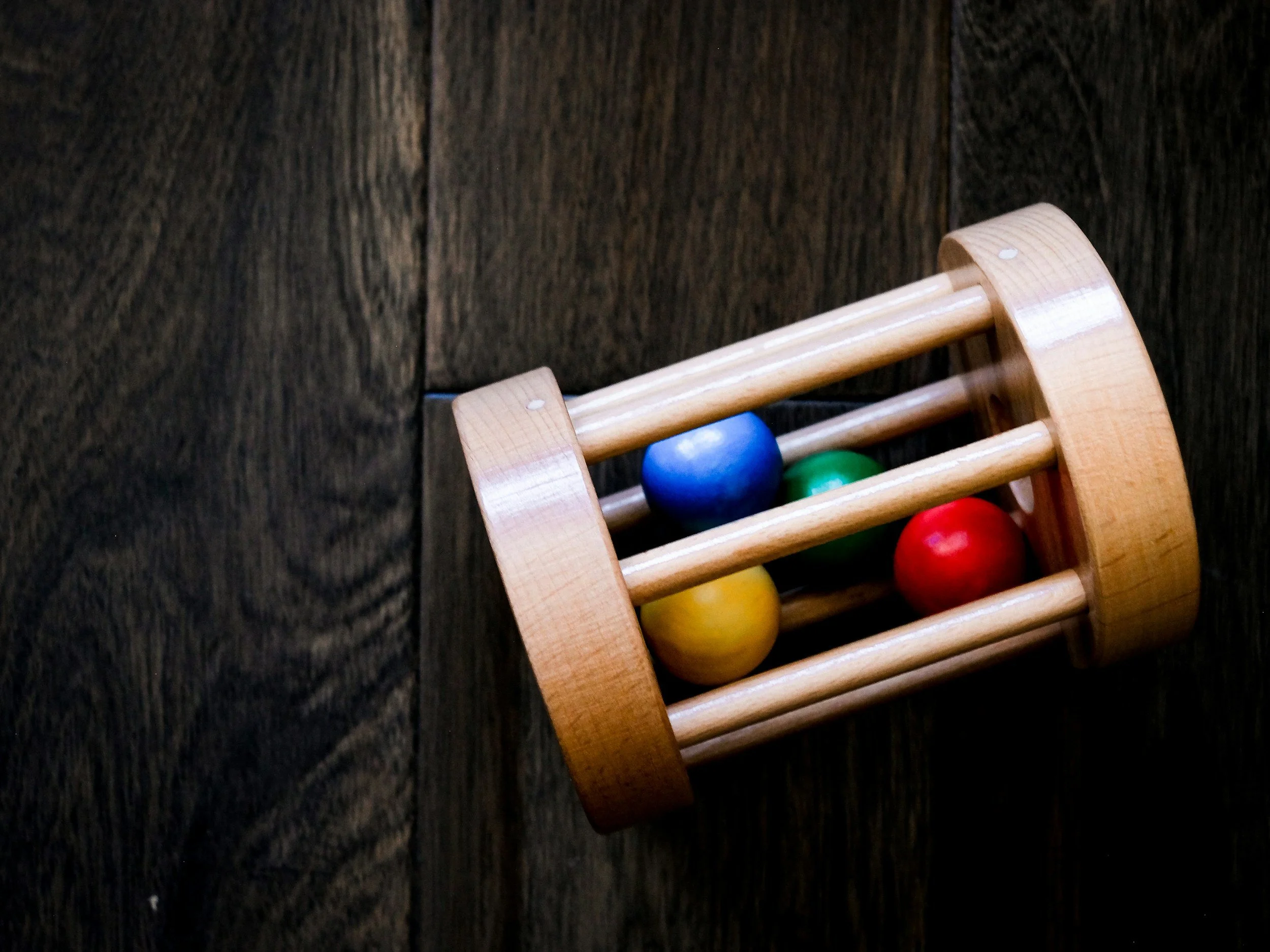 montessori infant toy wooden rattle to support gross motor milestones and crawling in a prepared environment montessori home design