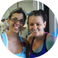 Two women smiling and posing together indoors, wearing casual clothing.