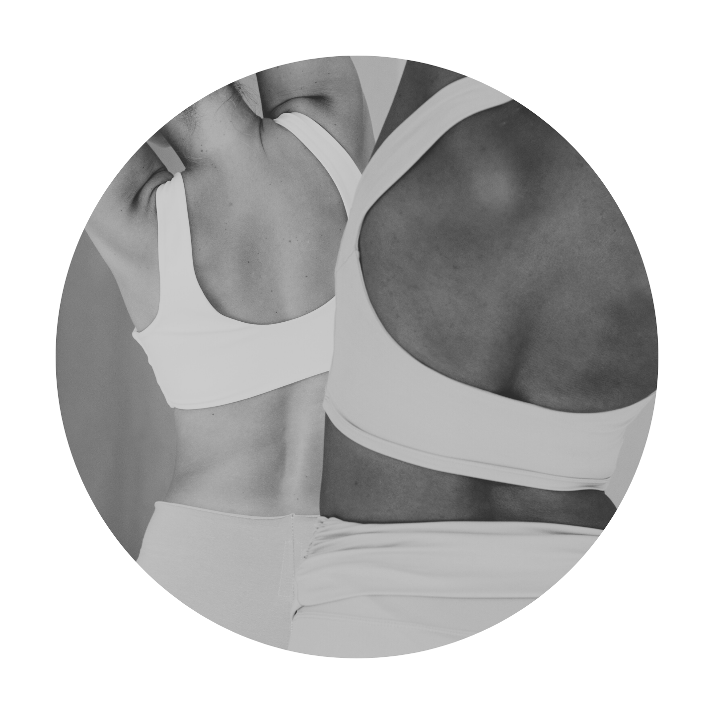 Close-up of two women in athletic wear, focusing on their torsos. One woman has a light skin tone, the other darker, both wearing sports bras. The image is in black and white.