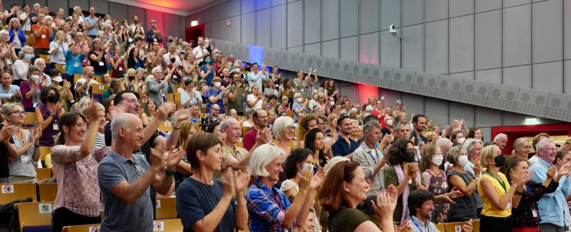 Over 100 attendees applauding in a large auditorium at the Technische Universität (Berlin Institute of Technology) during the International Alexander Technique Congress.