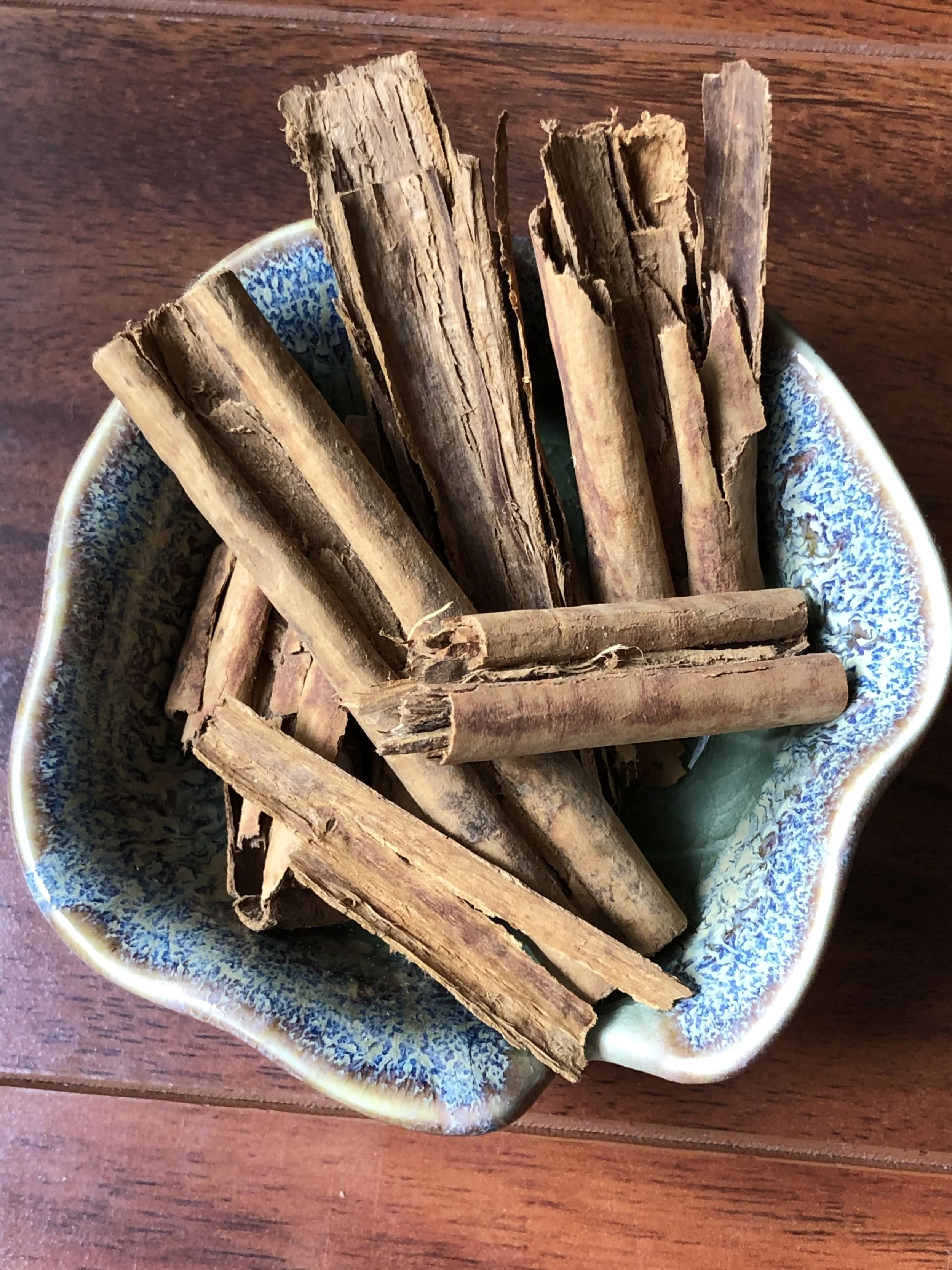 Cinnamon sticks in a small blue ceramic bowl