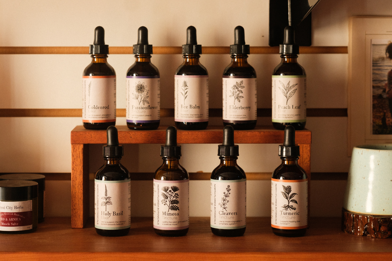 A display of nine brown dropper bottles each labeled with their contents.