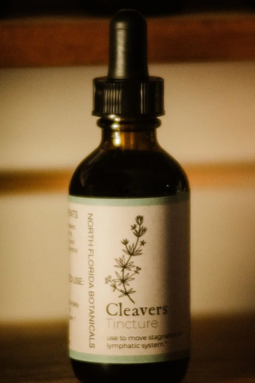 Close up of a brown dropper bottle labeled Cleavers.