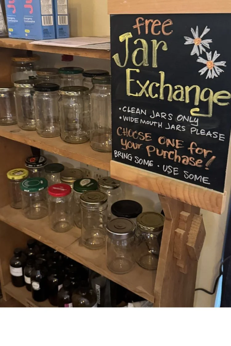 Shelves filled with empty, clear jars and a sign that reads Free Jar Exchange.