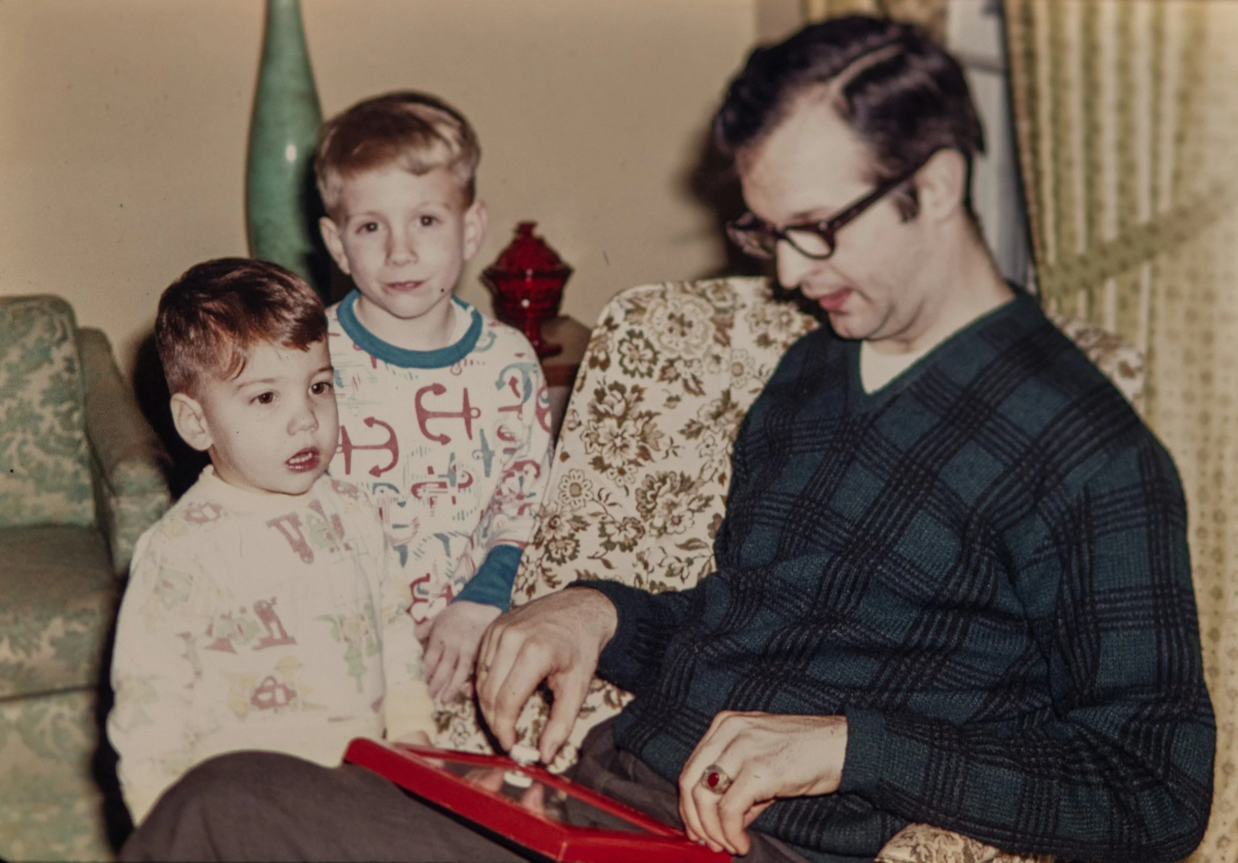 Father sharing an old family photo with his children, representing why people book a Legacy Conversations story session