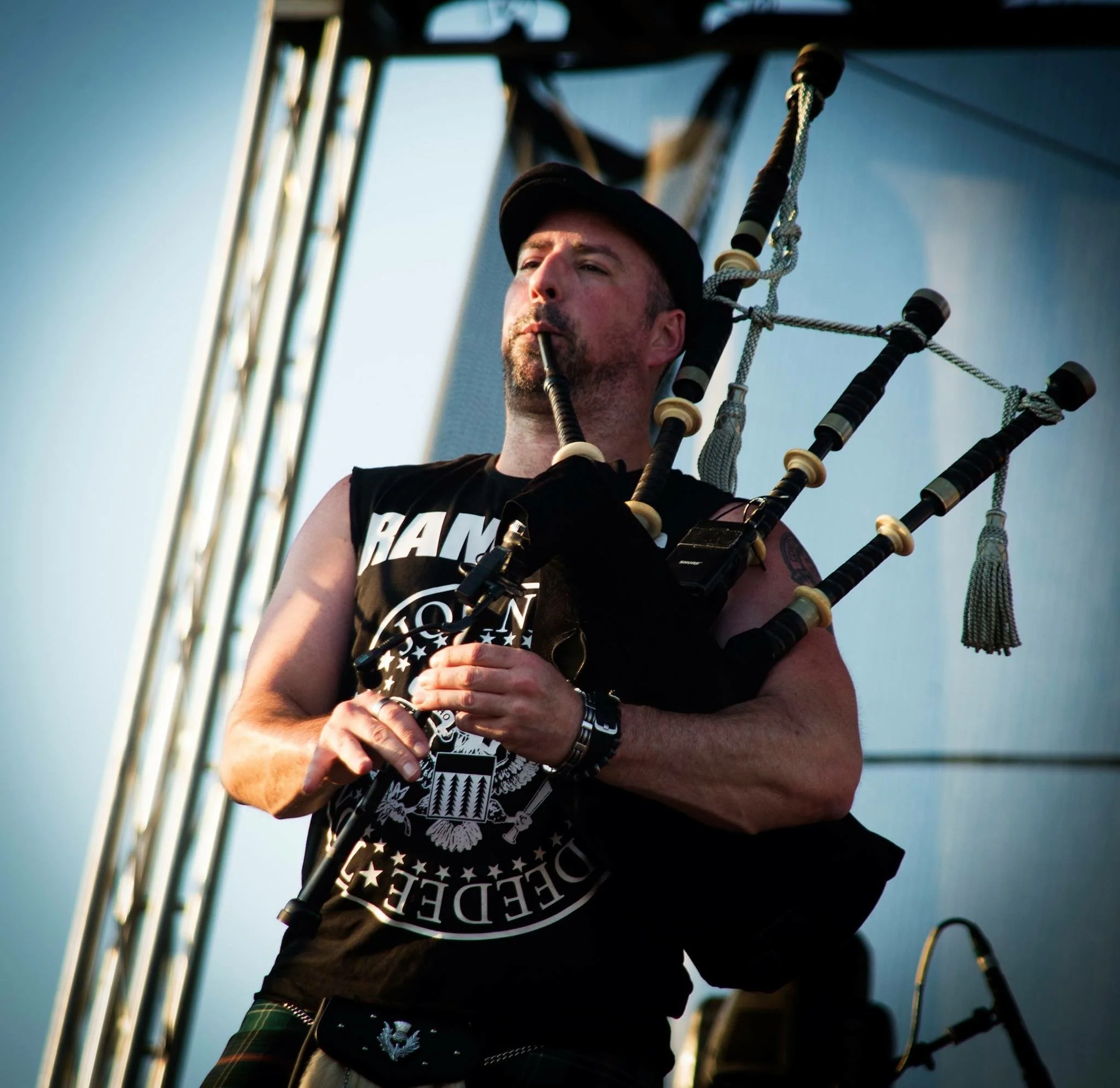 A man playing the bagpipes on stage during a live performance.