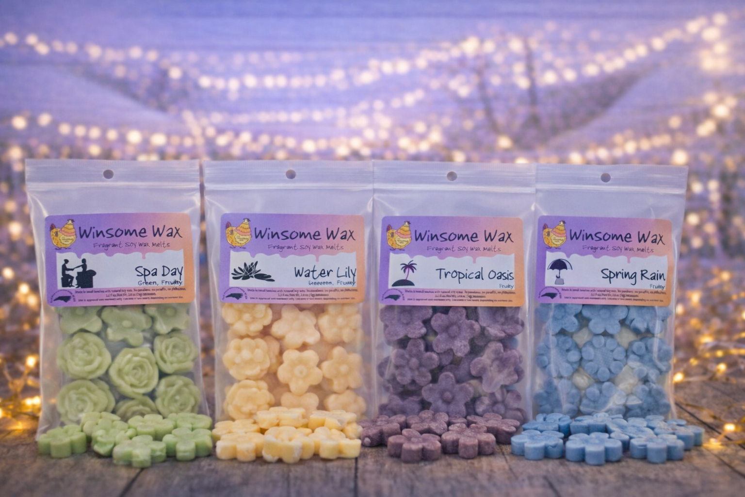 Four packages of Winsome Wax fragrant soy wax melts labeled 'Spa Day', 'Water Lily', 'Tropical Oasis', and 'Spring Rain' displayed on a wooden surface with blurred string lights in the background.