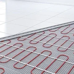 Heated flooring system with red heating cables installed on a concrete surface