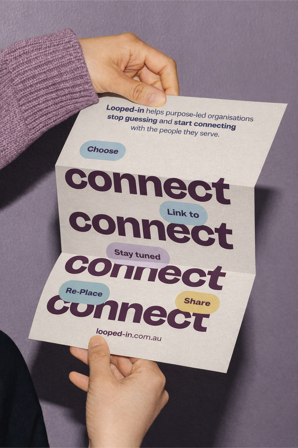 A person holding a folded paper flyer promoting the concept of connecting and engaging with others, featuring the words 'connect,' 'link to,' 'stay tuned,' 're-place,' and 'share,' along with descriptions about purpose-led organizations and a website URL.