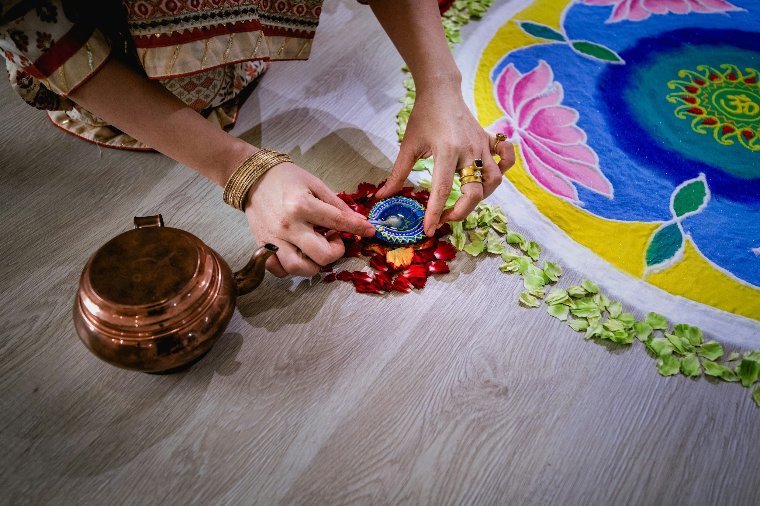 Hands creating a colourful mandala artwork during a creative workshop.
