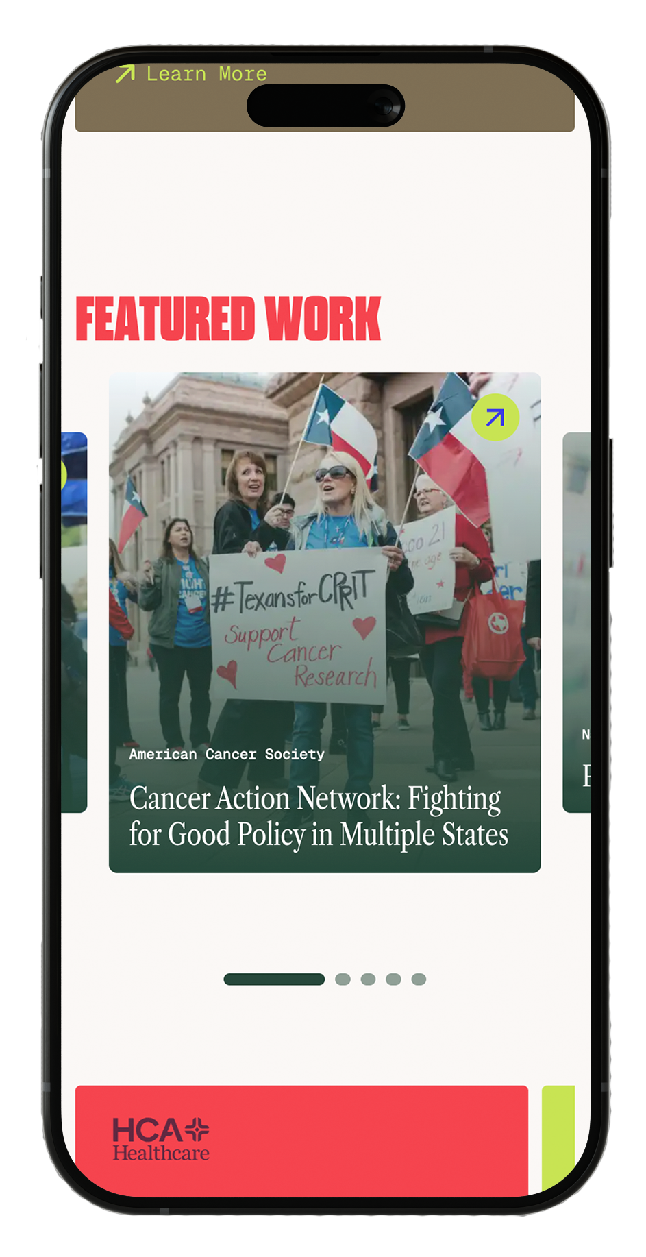 A mobile phone screen displaying a webpage with a featured work article about the American Cancer Society, showing a photo of women protesting with flags and signs, including one sign that reads #TexansforCRRT, Support Cancer Research.