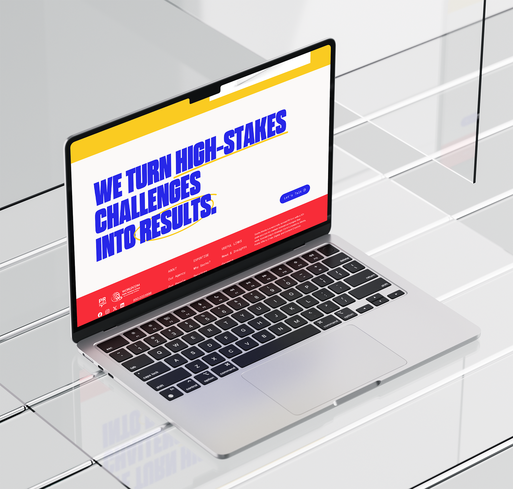 Open laptop with a colorful website on the screen, displaying the statement 'We turn high-stakes challenges into results' in bold blue text, sitting on a reflective white tiled surface.