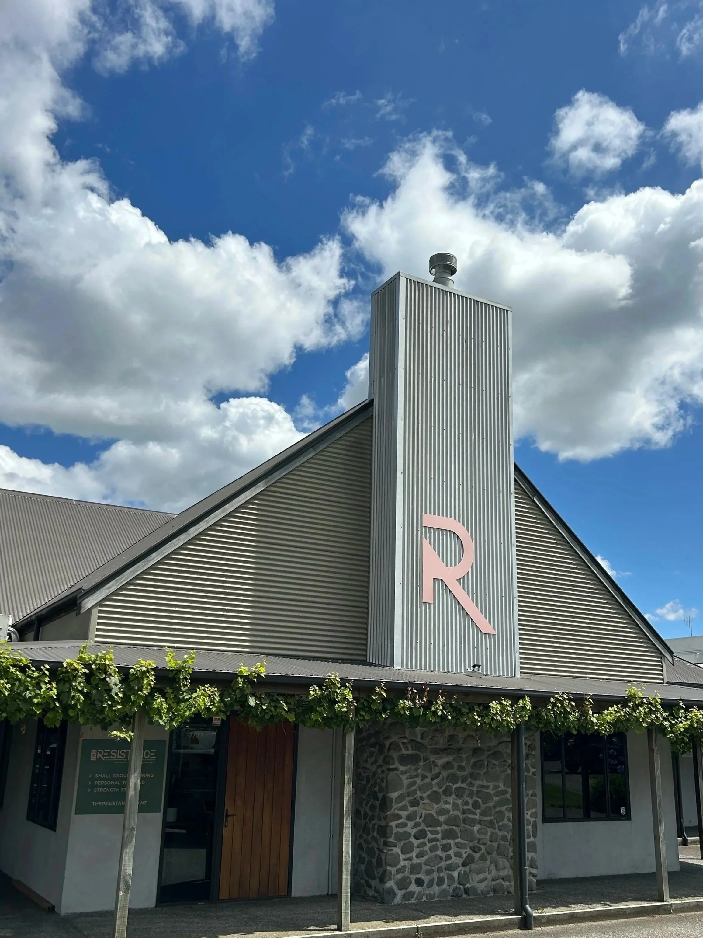 The Resistance premises building on Napier Road, Havelock North, under a blue sky, large R icon building signage.
