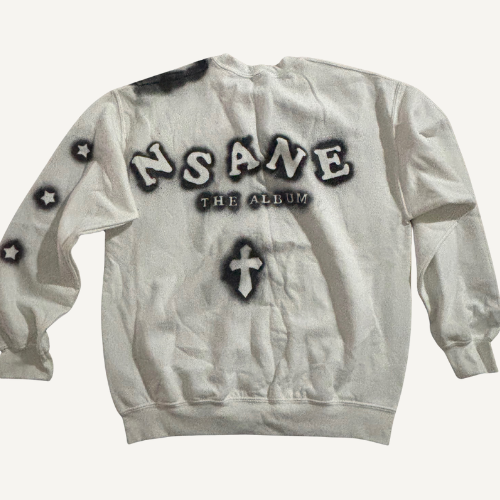 White sweatshirt with black and white text and symbols, including the words 'NSANE THE ALBUM' and a cross symbol.