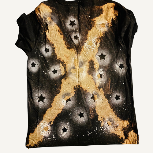A sleeveless top with a black, white, and gold galaxy-inspired design featuring star-shaped cutouts.