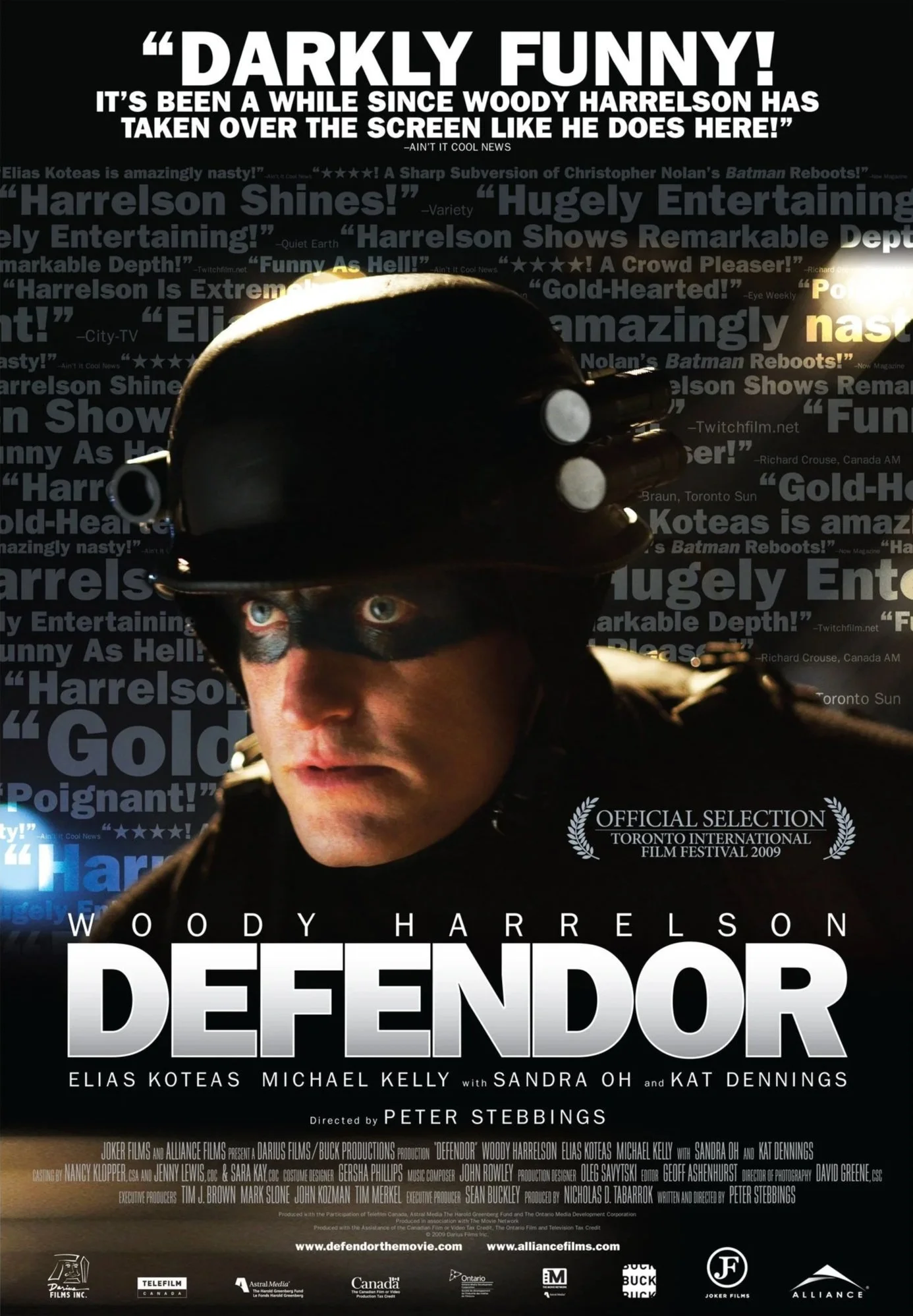 Movie poster for 'Defendor' featuring Woody Harrelson wearing a helmet with goggles, with background text in blue and white.